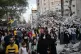 People pass the rubble of a building destroyed by Israeli ai