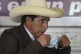 Pedro Castillo removes his mask in order to speak a press co