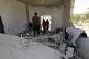 People inspect a damage house after shelling hit the town of