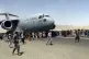 Hundreds of people run alongside a US Air Force transport pl