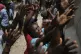 Earthquake victims reach for water being handed out during a