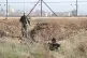 Israeli soldiers take positions along the border between the