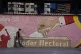 A man walks past a mural with an image of a ballot being cas