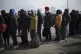 Refugees wait in a line to enter a bus after fleeing from Uk