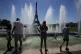 Tourists stand next to the fountains of Trocadero next to th
