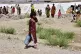 A flood victim walks to get drinking water at a relief camp 