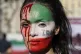 A woman is painted on a her face during a protest against th