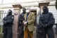 Masked police officers lead Heinrich XIII Prince Reuss to a 