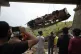 People watch rescuers use a crane after a bus carrying Hindu