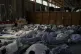 Survivors of a shipwreck sleep at a warehouse at the port in