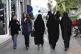 Iranian women make their way along a sidewalk in downtown Te