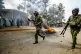 Riot policemen walk past a burning barricade during clashes 