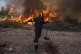 A firefighter leaves as the flames approaching him during a 