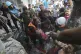 Palestinians rescue a child from under the rubble after Isra