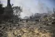 Palestinians boy walks by the buildings destroyed in the Isr