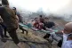 Palestinians evacuate two wounded boys out of the destructio