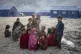 Afghan refugee children warm themselves with fire in a camp 