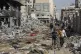 Palestinians walk through destruction in Gaza City on Friday