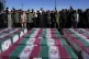 People pray over the flag-draped coffins of victims of  a te