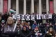 Protesters hold up banners, flags and placards in front of t