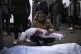 A man holds the body of his daughter who was killed in the I