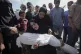 A woman holds the body of her daughter Zena Naser, killed in