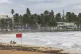 Tourists sit on La Pared beach as Tropical Storm Ernesto pas