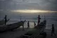Senegalese youth gather around pirogues on the beach at dusk