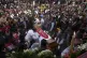 People gather around the coffin of slain Catholic priest and