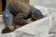 A man cries over the bodies of two children killed by Israel