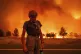 Grant Douglas pauses while evacuating as a wildfire reaches 