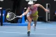 Iga Swiatek of Poland plays a backhand return to Emma Navarr