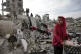 Members of the Nijim family hang laundry on the ruins of the