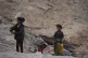 Displaced Palestinians girls fill a plastic jerrycan with wa