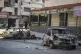 Burnt cars remain in the middle of a street following the re