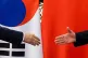 South Korean President Moon Jae In, left, shake hands with C