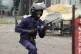 A member of the Congolese security forces chases people duri