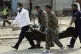 Security personnel carry a body at the site of a suicide att