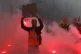 A French railway worker holds a poster among flares during a