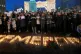 People stand in front of the word Kemerovo, made up of candl