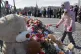 A girl puts flowers at the foot of the Alexander Column at D