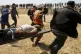 Palestinian protesters and civil defence evacuate a wounded 