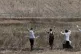 Palestinian medics raise their hands toward the fence to eva