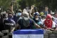 Masked protesters yell from the road block they erected as t