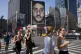 New Yorkers walk past a Nike advertisement featuring former 