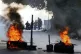Bolivarian National Police stand behind a burning roadblock 