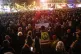 A man wearing a yellow vest holds a placard reading ‘I am 