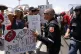A police officer tries to remove anti-Trump demonstrators fr