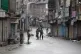 Indian Paramilitary soldiers stand guard on a deserted stree