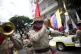 A Bolivarian militia member plays the trumpet with his face 